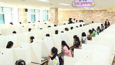 Students eat lunch while separated by partitions at a school in Daejeon, South Korea, on Wednesday. EPA