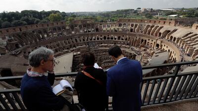 Journalists look out from topmost level of the ancient Colosseum. Andrew Medichini / AP Photo
