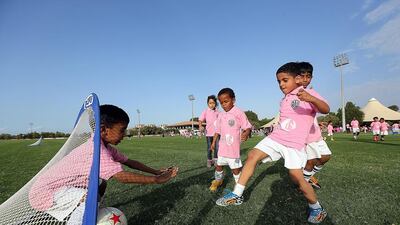 Children play football at The Pink Polo event.