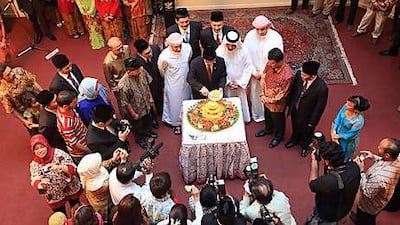 Surrounded by guests, Wahid Supriyadi, centre, the Indonesian ambassador to the UAE, cuts a cake to celebrate the island nation's independence at the embassy in Abu Dhabi.