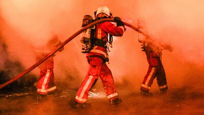Firefighters extinguish a bus set on fire during clashes between protesters and riot police, in Nanterre. EPA