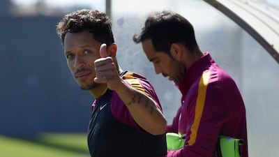 Barcelona’s Brazilian defender Adriano (L) thumbs up as he arrives with Barcelona’s Chilean goalkeeper Claudio Bravo for a training session at the FC Barcelona Joan Gamper Sports Centre in Sant Joan Despi, near Barcelona on April 16, 2015, on the eve of the La Liga match FC Barcelona v Valencia CF. AFP / LLUIS GENE