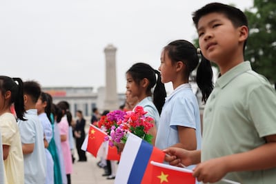 Children holding flags and flowers take part in a ceremony to welcome Russian President Vladimir Putin to the Great Hall of the People in Beijing. EPA