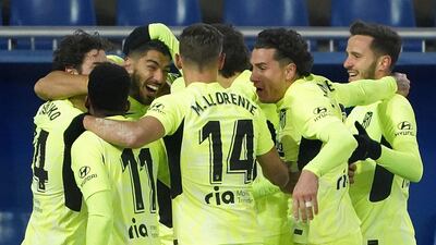 Atletico 's Luis Suarez is mobbed by teammates after scoring. AFP