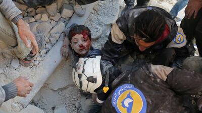 The White Helmets, Syrian civil defence volunteers, rescue a boy from the rubble in Aleppo last month. Ameer Alhalbi / AFP.