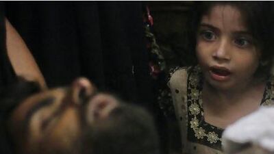 Eight-year-old Sumayya, whose uncle, Imran Ali, was injured in a shootout in Karachi yesterday, watches as he is brought to hospital for treatment.