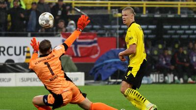 Bayern goalkeeper Manuel Neuer saves from Erling Braut Haaland.