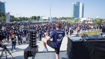 A runner leads hundreds in stretching together.