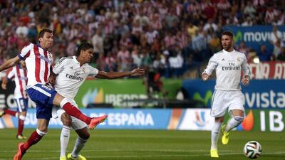 Atletico Madrid's Mario Mandzukic kicks to score past Real Madrid's Raphael Varane, left, and Sergio Ramos, right, during the Spanish Super Cup on Friday. Juan Medina / Reuters