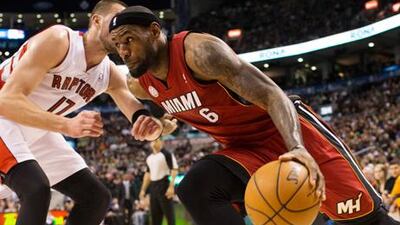 Miami Heat's LeBron James drives past Toronto Raptors' Jonas Valanciunas.