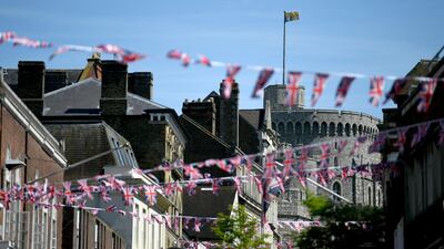 Bunting is displayed in Windsor, where Prince Harry and his fiancee Meghan Markle will marry at the castle on Saturday, but it is unknown who will give the bride away. Neil Hall / EPA