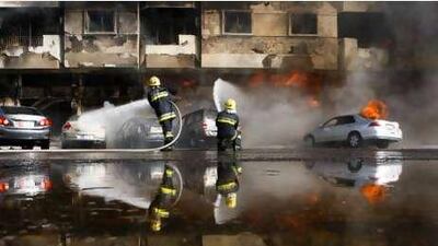 Firefighters battle the blaze, which spread to several parked cars. Police could not confirm the cause of the fire.