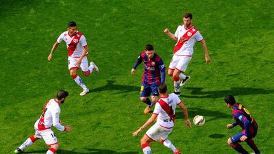 Lionel Messi and Luis Suarez of Barcelona compete for the ball among Rayo Vallecano players on Sunday during their La Liga match at the Camp Nou. David Ramos / Getty Images