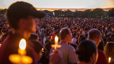 Hundreds of community members take part in a candlelight vigil at the Amphitheater at Pine Trails Park. Giorgio Viera / EPA