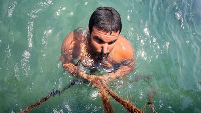 A Kuwaiti diver searches for shells containing pearls during the annual pearl diving season off the coast of the port city of Khairan. AFP