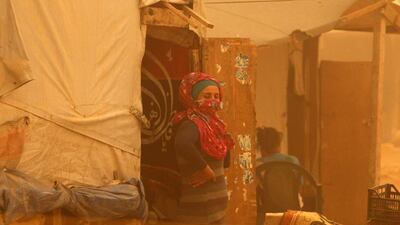 A Syrian woman stands outside her tent at a refugee camp on the outskirts of the eastern Lebanese city of Baalbek. AFP Photo