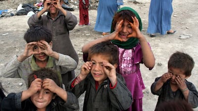Afghan children play outside temporary shelters in Kabul, in October 2009. EPA