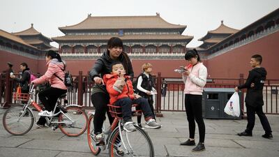 Visitors ride bicycles from the bike-sharing company Mobile in Beijing on March 22, 2017. Andy Wong / AP Photo