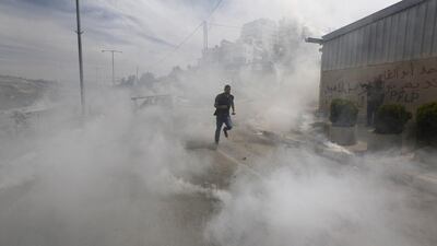 A Palestinian protester runs from tear gas fired by Israeli troops during clashes near Israel’s Ofer Prison, near the West Bank city of Ramallah. Mohamad Torokman / Reuters