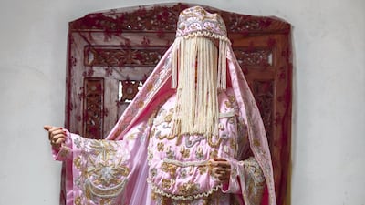 MADINAH BRIDE: Worn by brides in the Madinah region in western Saudi Arabia, this bright pink style of dress features many layers, including those over the face. Today, brides might choose to wear this on their henna night, as they will now often wear a more western-style white dress on their wedding night. All photos Hussain Haddad for The National