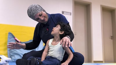 Physiotherapist Ibtesam Namoura works with Mohammed Al Mahri, 2, who suffers from cerebral palsy. Christopher Pike / The National