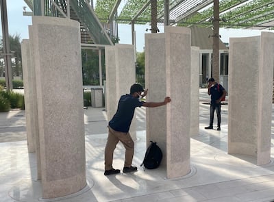 Workers seek out their names on the monument to their efforts at Expo 2020 Dubai. Photo: James Langton / The National