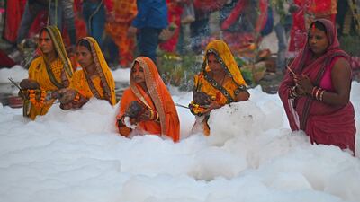Devotees offer prayers to the Sun god while standing in the water. AFP