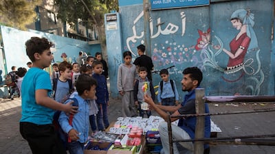 A vendor tries to sell candy to Palestinian school children outside the UNRWA Asma Coed Elementary school in The Shati refugee camp in Gaza City.