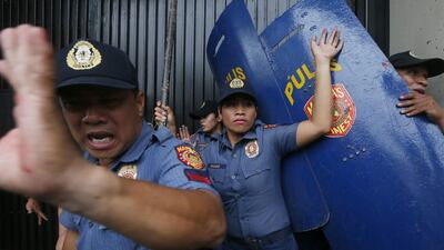 Riot police try to stand their ground as protesters force their way closer to the gates of the US embassy.