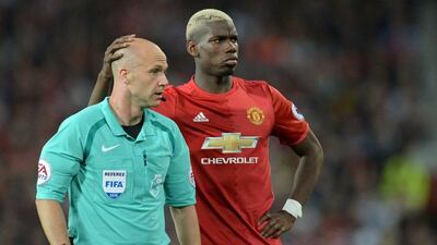 Paul Pogba shares a moment with referee Anthony Taylor. Oli Scarff / AFP
