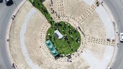 An aerial view shows people planting trees at a roundabout south of Kuwait City on April 29, 2023, as part of a afforestation campaign. (Photo by YASSER AL-ZAYYAT / AFP)
