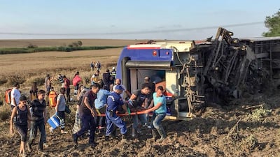 People and rescuers carry an injured woman after a train accident at Corlu district in Tekirdag, on July 8, 2018. Turkey OUT / AFP