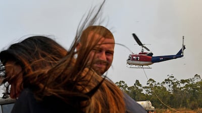 Commuters are seen as a Rural Fire Service (RFS) helicopter lands on the Princes Highway near the town of Sussex Inlet. Getty