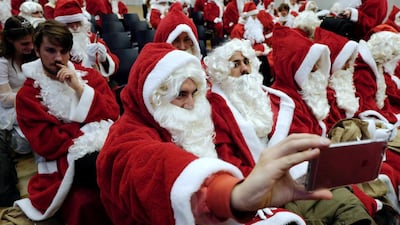 A student dressed up as Father Christmas takes a selfie as he waits for the start of a Father Christmas workshop organised by Studenwerk Berlin, a student organisation in Berlin. Students, after completing the workshop, are bookable for a fee over the holiday season. AFP