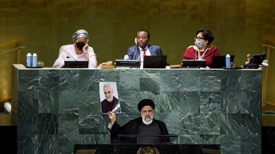 Iranian President Ebrahim Raisi holds up a picture of Qassem Suleimani as he addresses the UN General Assembly. AFP
