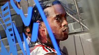 AC Milan's Ronaldinho looks through the glass of a dugout as he gives an interview at the Al Nasr Stadium in Dubai.