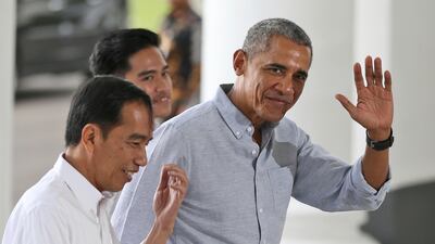 Former US president Barack Obama waves to reporters as he walks with Indonesian president Joko Widodo, left, in Bogor, Indonesia on June 30, 2017. Dita Alangkara, Pool, File / AP