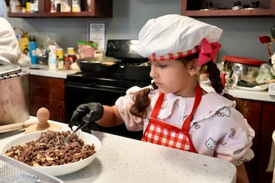 Maria, 7, helps her parents during the cooking demonstration at George Washington University