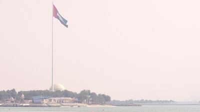The UAE flag at the Corniche, Abu Dhabi on a sunny but hazy day. Victor Besa / The National