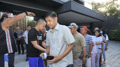 Fans and well-wishers line up in Manny Pacquiao's residence to receive "blessings" for Christmas. Each person receives one thousand pesos as a gift. Jake Verzosa for The National