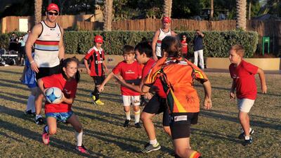 Joining Jack’s Andy Farrell, left, instructs children during an Emirates rugby clinic in Dubai. Farrell will be in action this weekend at the Dubai Rugby Sevens. Courtesy photo