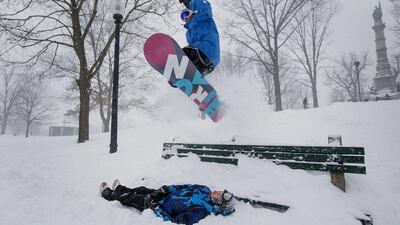 A snowboarder jumps over a friend at Boston Common during winter storm Juno. Bloomberg/ Scott Eisen