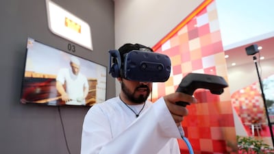 Hamad Al Shehhi trying out the pearl diving voyage VR experience at Corniche Al Qawasim Innovation Festival in Ras Al Khaimah. Chris Whiteoak / The National