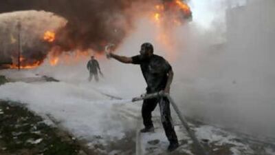 Palestinian firefighters try to extinguish flames at a medicine storehouse after an Israeli airstrike targeted at a fuel tank nearby in southern Gaza Strip town of Rafah on Dec 28 2008.