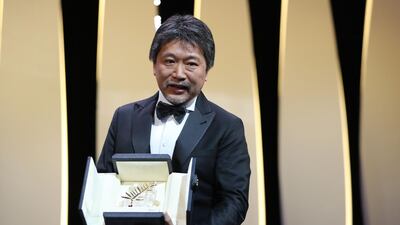 Japanese director Hirokazu Kore-Eda poses on stage after he was awarded with the Palme d'Or for the film Shoplifters on May 19, 2018 during the closing ceremony of the 71st edition of the Cannes Film Festival in Cannes, southern France. / AFP / Valery HACHE