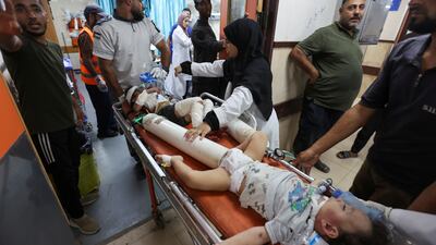 Injured children are carried into Al-Aqsa Martyrs Hospital in the aftermath of an Israeli strike on October 2. Ramadan Abed / Reuters