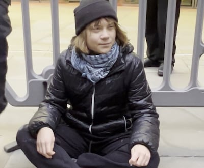 Greta Thunberg sitting on the ground outside the offices of Aspen Insurance on Fenchurch Street, London. PA