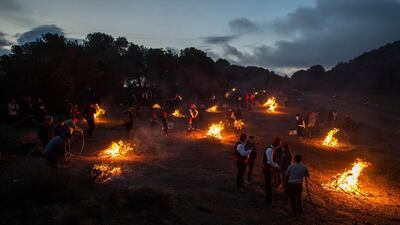 'Galejadors' light bonfires in the forest during 'la Festa del Pi' (The Festival of the Pine) in Centelles, Spain. Early in the morning men and women born in Centelles, who are named 'Galejadors' wear their traditional costume with the Catalan red hat known as 'Barretina' and carry their shooting muskets as they walk into the forest to chop down a pine tree, load it on an ox cart and take it to the church in the village. The pine tree is decorated with five bouquets of apples and wafers and hung inside a church until January 6. The tradition has been documented since 1751 and it is believed its origins are related to the trees and the pagan worship of fertilisation related to the winter solstice. David Ramos / Getty Images