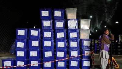 An Afghan election commission worker stands next to ballot boxes and election material in a warehouse in Kabul. Reuters