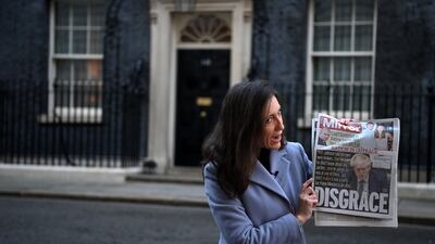 A member of the international media holds up a newspaper front page outside 10 Downing Street as Boris Johnson's polling rating slumps after Partygate. EPA